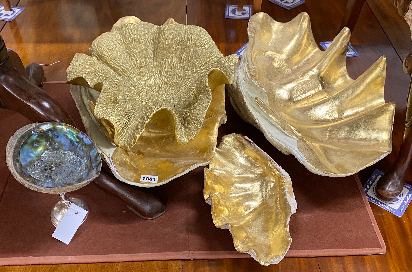 Four gilt composition scallop shells and an abalone shell on silver stand, largest width 57cm